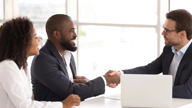 Lawyer Shaking Hands With Client At Desk