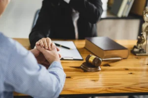 Lawyer Holding Hand Of Client At Desk