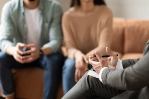 Couple Sitting On Couch Discussing With Attorney