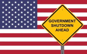 Government Shutdown Ahead Yellow Sign In Front Of American Flag Representing Government Shutdown