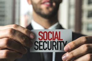 Man Holding Card In Front Of Him That Says Social Security In All Caps Font