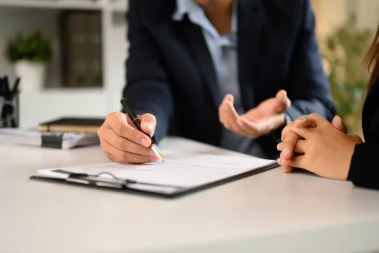 Attorney reviewing a representation agreement with a client at a desk